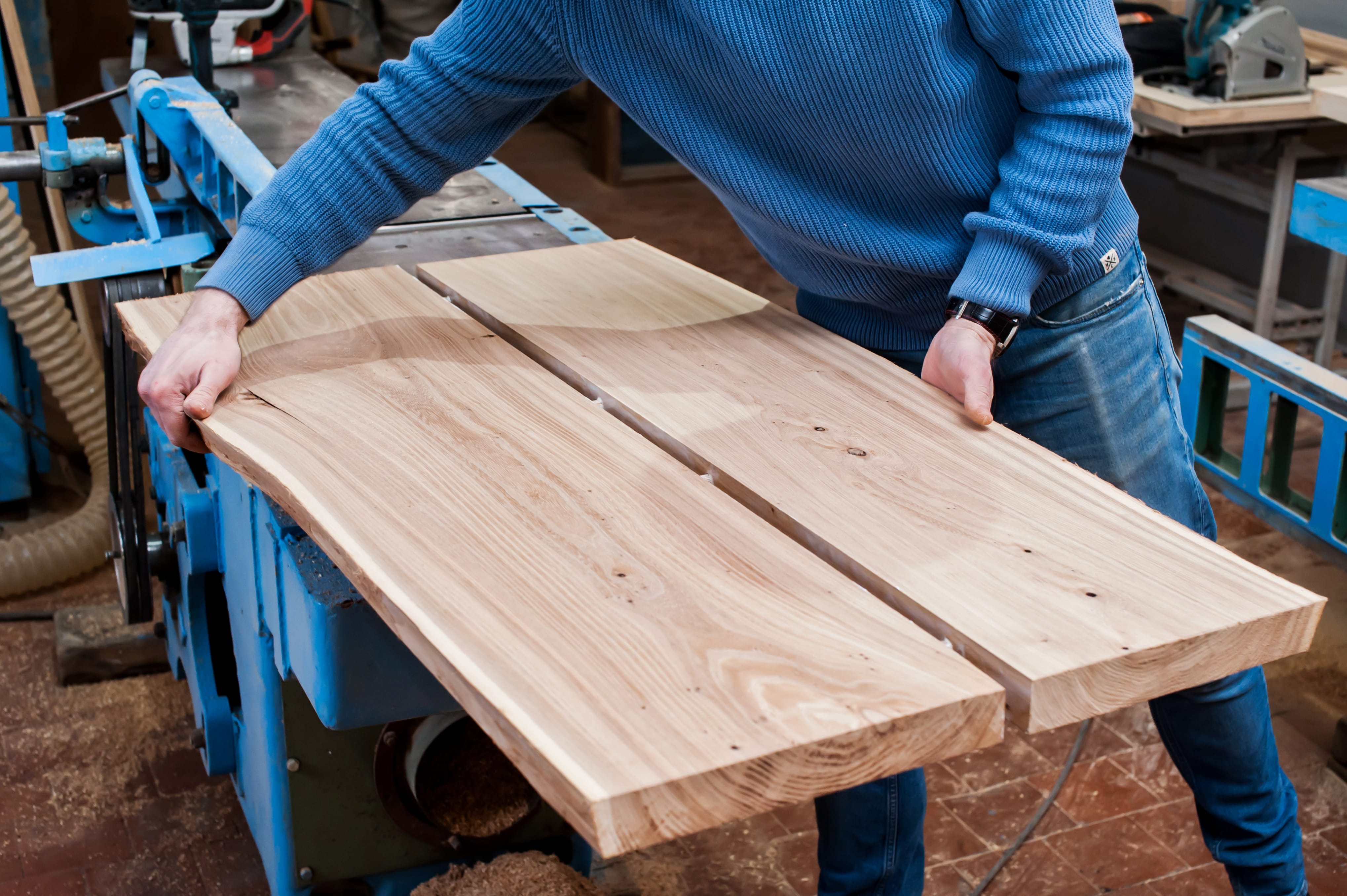 Man gluing planks in a carpentry workshop